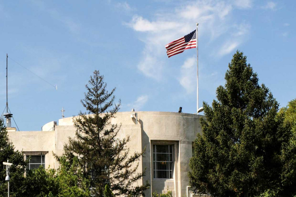 Insiden penembakan tersebut terjadi saat Ankara dan Washington sedang terlibat pertikaian sengit karena penahanan pendeta asal AS, Andrew Brunson, oleh pemerintah Turki. Pendeta itu dituduh terlibat dalam tindak terorisme. Di lain hal, Presiden AS Donald Trump telah melipatgandakan pajak ekspor aluminium dan baja atas impor dari Turki. Hal itu kemudian mendorong Ankara mengenakan tarif tinggi terhadap beberapa produk AS. 