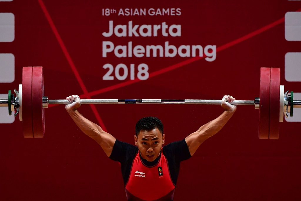 Lifter Indonesia Eko Yuli melakukan angkatan 'Snatch' angkat besi putra grup A nomor 62 kg Asian Games ke-18 di Jiexpo, Kemayoran, Jakarta. Afp Photo/Money Sharma
