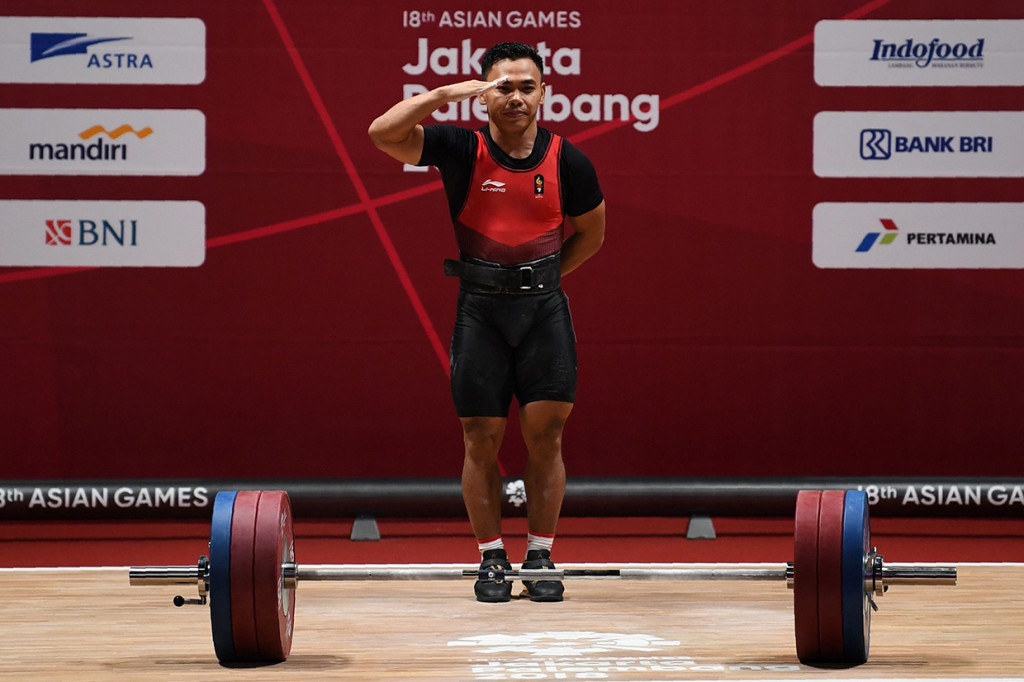 Lifter Indonesia Eko Yuli melakukan setelah memenangkan medali emas angkat besi putra grup A nomor 62 kg Asian Games ke-18 di Jiexpo, Kemayoran, Jakarta. Afp Photo/Money Sharma