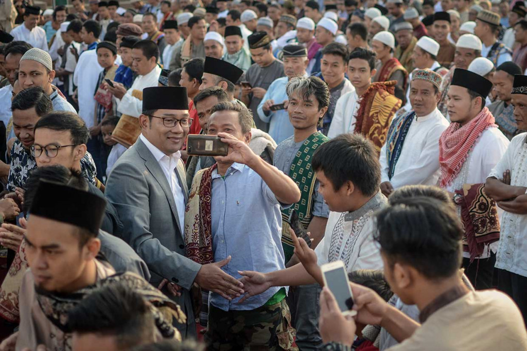 Wali Kota Bandung Ridwan Kamil berswafoto dengan jemaah usai melaksanakan Salat Iduladha di Alun-Alun Cicendo, Bandung. Dalam kesempatan tersebut, Ridwan Kamil berpamitan kepada jemaah serta memohon doa restu untuk menjadi Gubernur Jabar. Antara Foto/Raisan Al Farisi