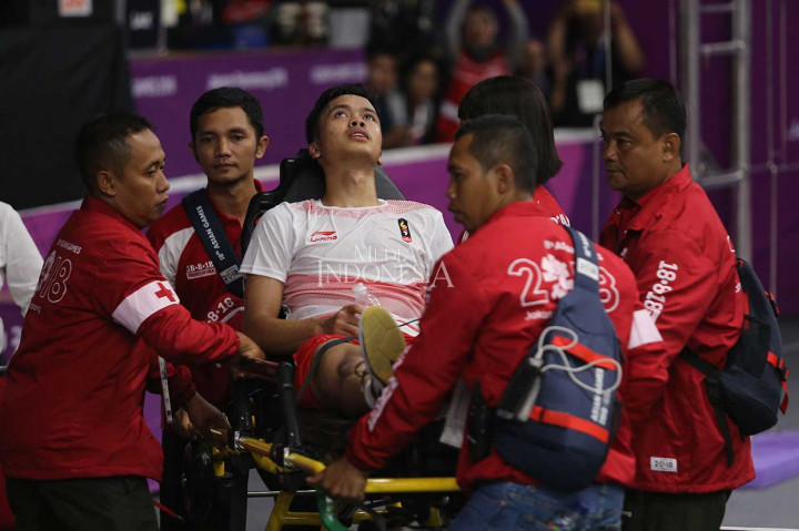 Anthony Sinisuka Ginting harus dibawa keluar lapangan dengan alat bantu oleh petugas medis setelah mengalami cedera saat melawan pebulutangkis Tiongkok Shi Yuqi pada laga pertama babak final beregu putra Asian Games 2018 di Istora Senayan, Jakarta, Rabu, 23 Agustus 2018 malam. 