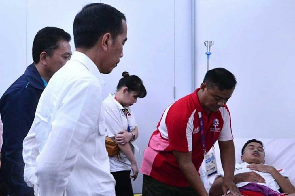 Presiden Jokowi mendatangi Anthony Sinisuka Ginting yang cedera saat bertanding melawan Shi Yuqi pada partai pertama final beregu putra Indonesia melawan Tiongkok. Jokowi menghampiri Anthony di ruang medis saat jeda pertandingan Marcus Fernaldi Gideon/Kevin Sanjaya Sukamuljo melawan pasangan Juara Dunia 2018 Li Junhui/Liu Yuchen. Setpres/Bey Machmudin