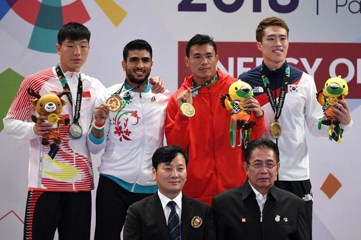 Atlet wushu Indonesia Puja Riyaya (kedua dari kanan) memperlihatkan medali perunggu yang diraihnya pada nomor sanda putra 70 kg Asian Games 2018. AFP Photo/Juni Kriswanto