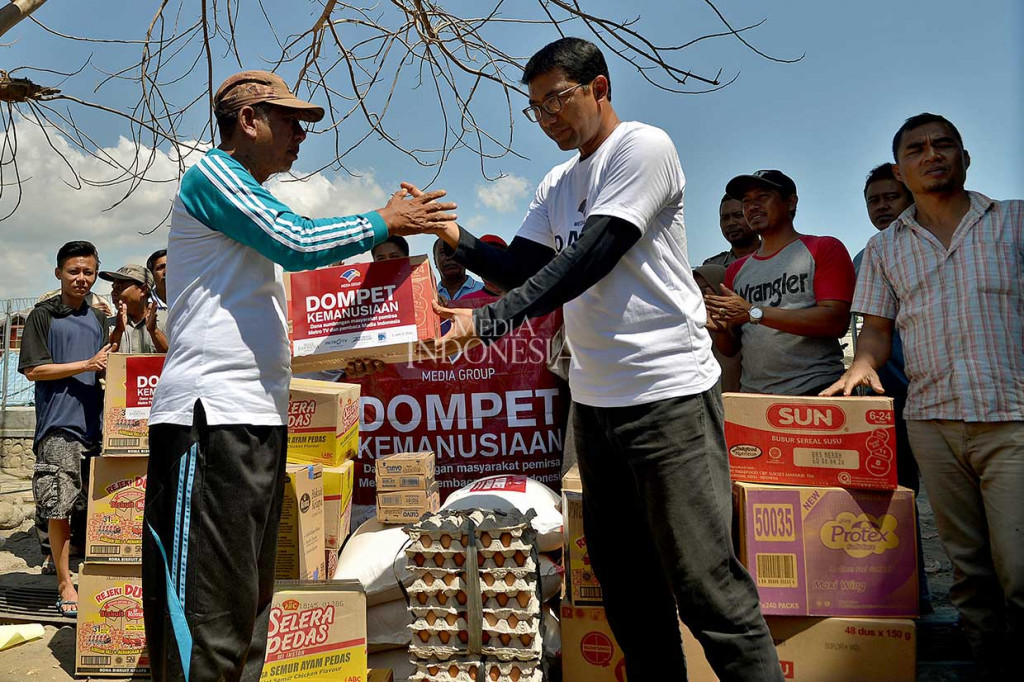 Ketua Yayasan Dompet Kemanusiaan Media Group Ali Sadikin (kanan) menyerahkan bahan keperluan logistik yang disalurkan melalui Dompet Kemanusiaan Media Group bagi pengungsi bencana alam gempa bumi di Desa Kalimango, Alas, Sumbawa, Nusa Tenggara Barat, Kamis, 23 Agustus. 
