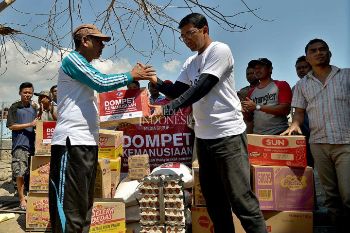 Ketua Yayasan Dompet Kemanusiaan Media Group Ali Sadikin (kanan) menyerahkan bahan keperluan logistik yang disalurkan melalui Dompet Kemanusiaan Media Group bagi pengungsi bencana alam gempa bumi di Desa Kalimango, Alas, Sumbawa, Nusa Tenggara Barat, Kamis, 23 Agustus. 