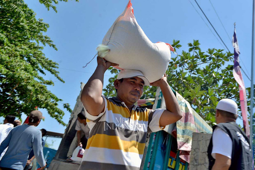 Warga bahu-membahu menurunkan bahan keperluan logistik yang disalurkan melalui Dompet Kemanusiaan Media Group bagi pengungsi bencana alam gempa bumi di Desa Kalimango, Alas, Sumbawa.