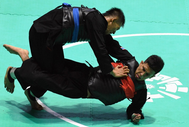 Iqbal Chandra Pratama (atas) menghdapi pesilat Thailand Porntep Poolkaew dalam babak 16 besar Kelas D Putra. Indonesia menargetkan minimal tiga emas dari cabang bela diri ini. INASGOC/Antara Foto/Melvinas Priananda