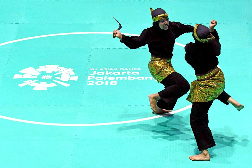 Dua pesilat putri menunjukkan ketrampilannya bersenjata celurit dalam upacara pembukaan pertandingan Pencak Silat Asian Games 2018 di Padepokan Pencak Silat Indonesia, TMII, Jakarta.  INASGOC/Antara Foto/Dewi Nurcahyani