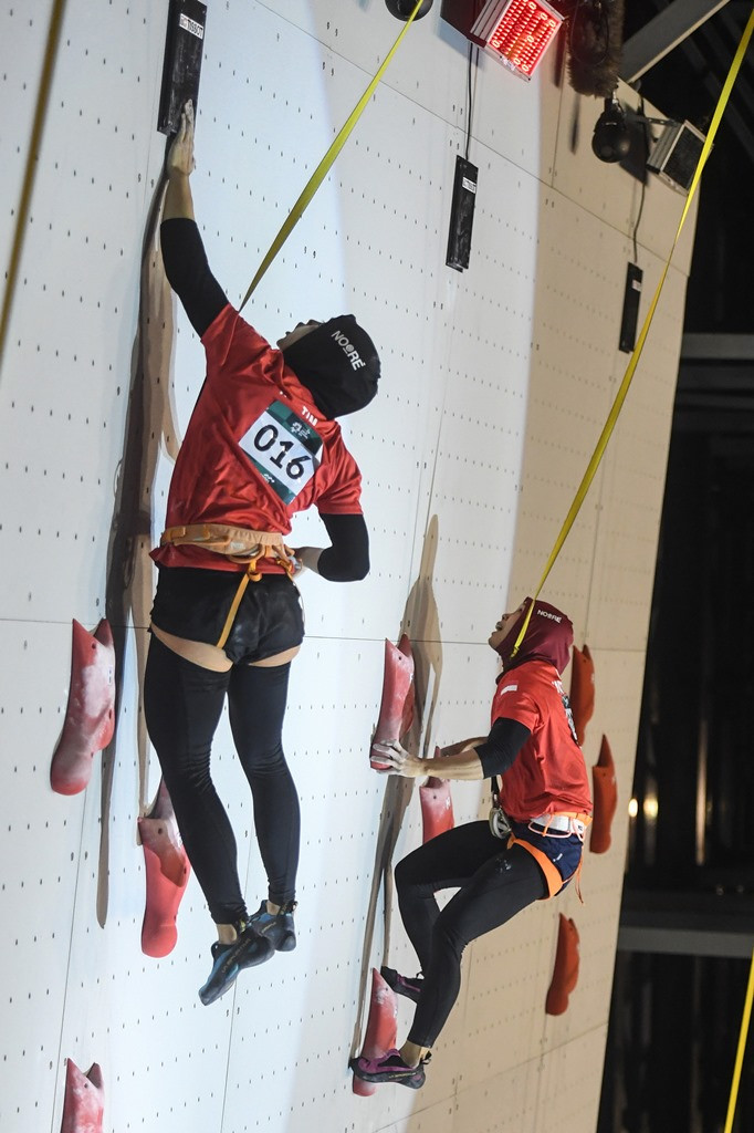 Aries Susanti Rahayu (kiri) beradu cepat dengan Puji Lestari (kanan) dalam final speed climbing putri di arena panjat tebing Jakabaring Sport City, Palembang. Kegigihan dua climber ini menghasilkan medali emas dan perak.  INASGOC/Antara Foto/Hendra Nurdiyansyah