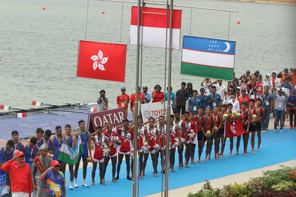 Regu dayung Indonesia, Uzbekistan, dan Hong Kong memberikan hormat kepada bendera negaranya seusai pengalungan medali.