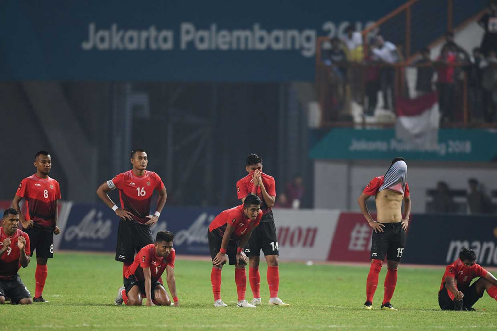 Para pemain Indonesia tertunduk lesu setelah gagal melangkah ke babak perempat final sepak bola Asian Games 2018. AFP Photo/Aamir Qureshi