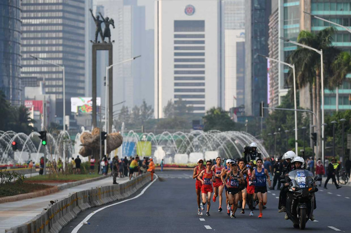Saat sejumlah atlet melintas di kawasan Bundaran Hotel Indonesia, Jakarta. Sebanyak 21 pelari dari 13 negara bersaing memperebutkan medali emas nomor lari yang menempuh jarak 42,195 km tersebut