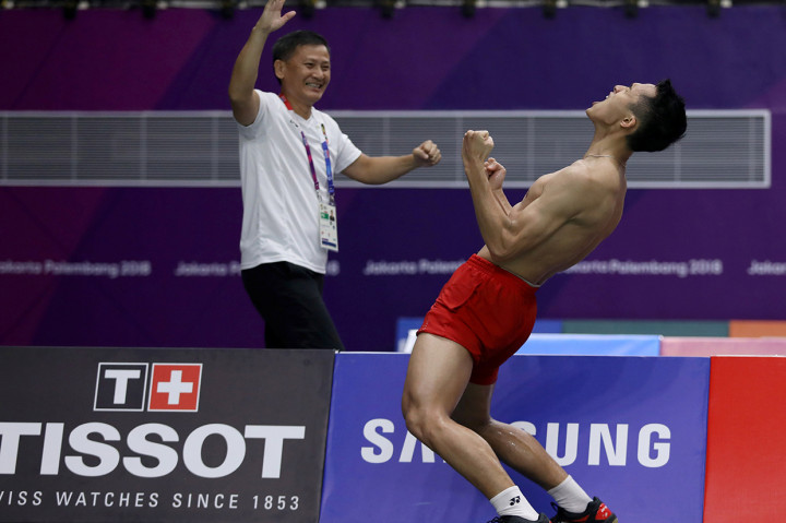 Selebrasi Jonatan Christie (kanan) dan pelatih Henry Saputra (kiri) usai menundukkan pebulu tangkis Jepang Kenta Nishimoto, pada pertandingan babak semifinal nomor perorangan Asian Games 2018 di Istora Senayan. Antara Foto/INASGOC/Nafielah Mahmudah