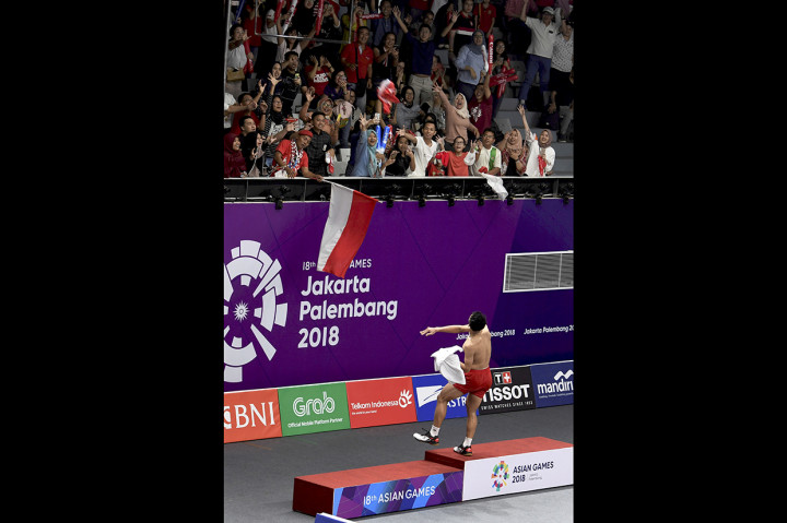 Jonatan Christie melemparkankan kaus ke arah penonton usai menundukkan pebulu tangkis Jepang Kenta Nishimoto, pada pertandingan babak semifinal nomor perorangan Asian Games 2018 di Istora Senayan, Jakarta. Antara Foto/INASGOC/Puspa Perwitasari