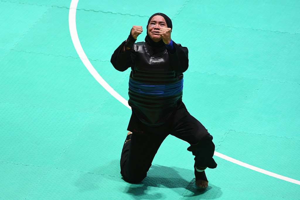 Ekspresi pesilat Indonesia Sarah Tria Monita usai mengalahkan pesilat Laos Nong Oy Vongphakdy (kiri) dalam babak final Kelas C Putri Asian Games 2018 di Padepokan Pencak Silat Taman Mini Indonesia Indah (TMII), Jakarta.