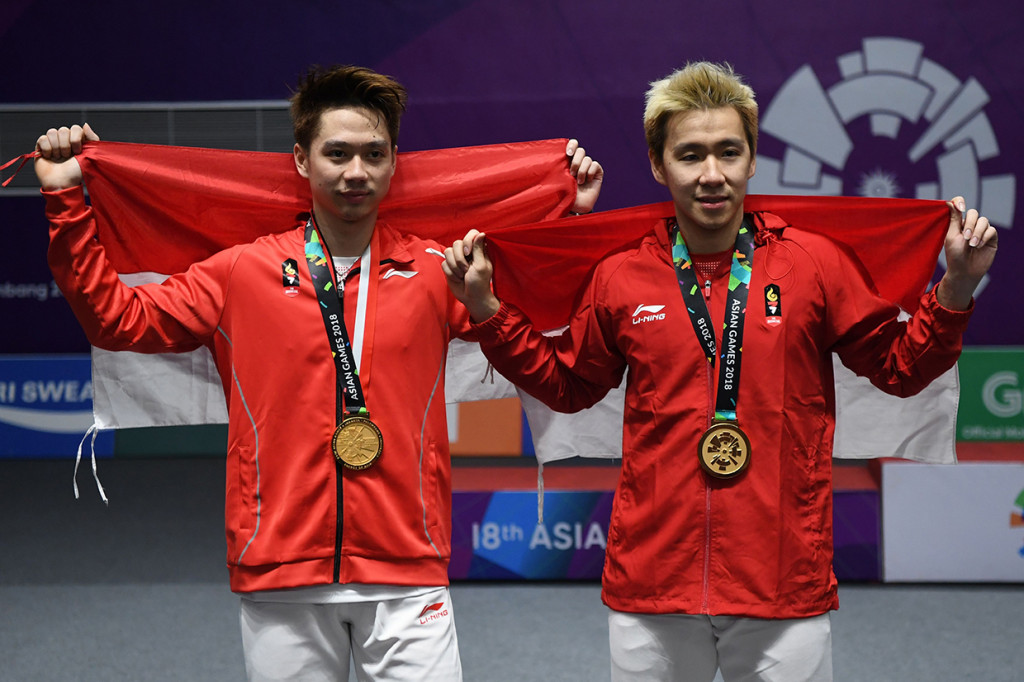 Medali emas Kevin/Marcus ini merupakan yang kedua dari cabor bulutangkis atau yang ke-24 untuk kontingen Indonesia. Sebelumnya, medali emas disumbangkan Jonatan Christie dari nomor tunggal putra usai mengalahkan pebulutangkis Taiwan, Chou Tienchen. Afp Photo/Sonny Tumbelaka