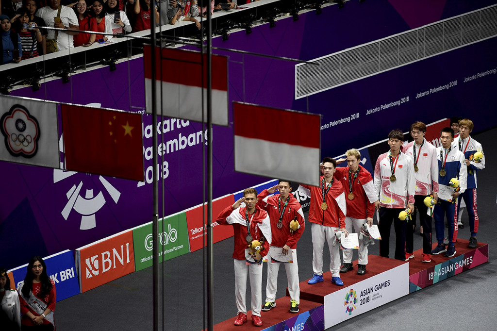 Pebulu tangkis ganda putra Indonesia peraih medali emas Marcus F Gideon dan Kevin Sanjaya, peraih medali perak Muhammad Rian Ardianto (kedua kiri) dan Fajar Alfian memberikan penghormatan kepada bendera Merah Putih pada upacara penyerahan medali di Istora Senayan, Jakarta. Antara Foto/INASGOC/Ismar Patrizki