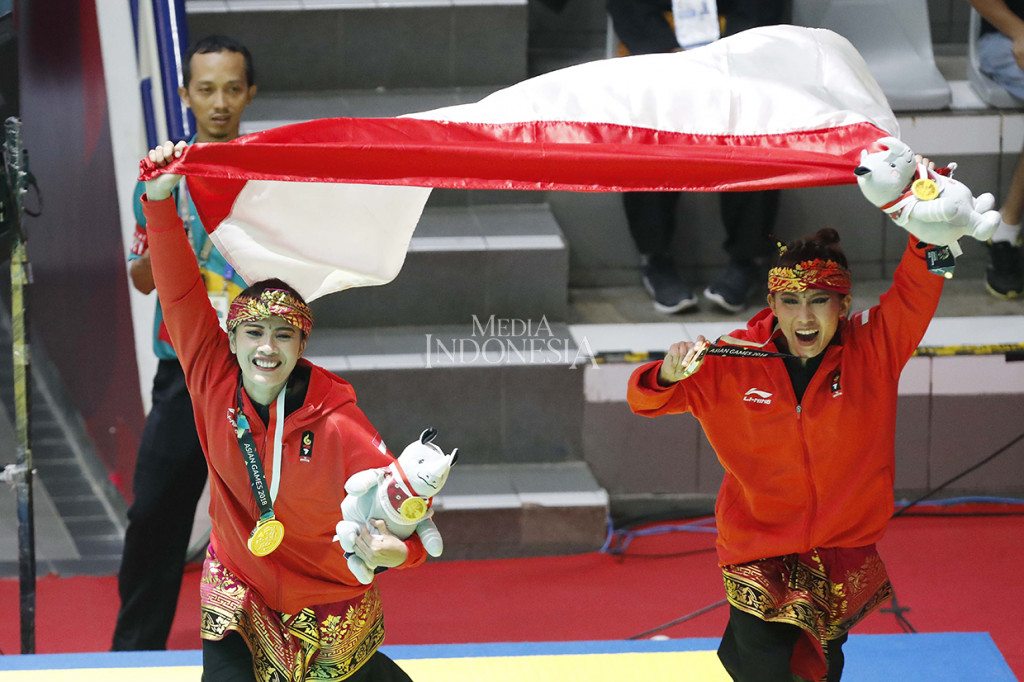 Pasangan pesilat Indonesia Ayu Sidan Wilantari dan Ni Made Dwiyanti melakukan selebrasi seusai memenangkan pencak silat nomor artistik ganda putri Asian Games 2018 di Padepokan Pencak Silat, TMII, Jakarta. MI/Rommy Pujianto