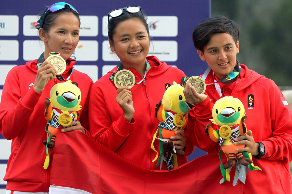 Atlet Indonesia (kiri-kanan) Lis Adriana, Rika Wijayanti dan Ike Ayu Wulandari menerima medali perunggu nomor lintas alam beregu putri cabang paralayang Asian Games 2018 di Gunung Mas Puncak, Bogor, Jawa Barat. Antara Foto/INASGOC/Crack Palinggi