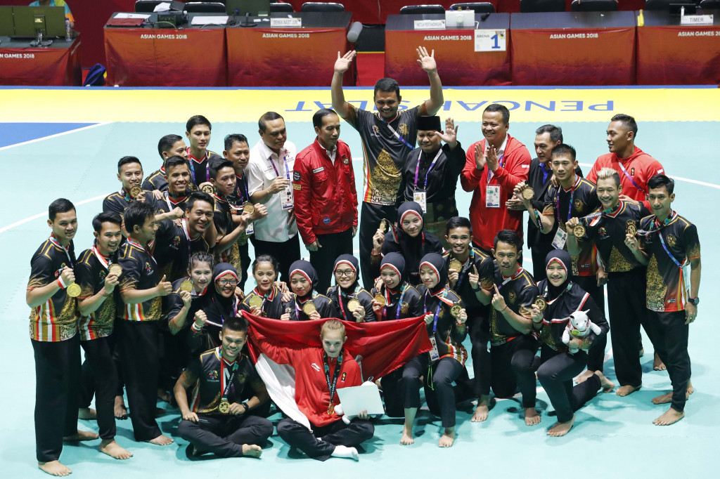 Presiden Joko Widodo bersama Ketua PB IPSI Prabowo Subianto berfoto bersama tim pencak silat Indonesia menyapa para pendukung yang menonton pencak silat Asian Games 2018 di Padepokan Pencak Silat, TMII, Jakarta.