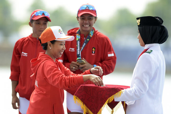 Menteri BUMN Rini Soemarno memberikan medali perunggu kepada atlet kano Indonesia Meni Nur (kiri) dan Riska Andriyani (kanan) usai mengikuti nomor final kano ganda putri 500 meter di danau Jakabaring Palembang, Sumatera Selatan. Antara Foto/INASGOC/Septianda Perdana