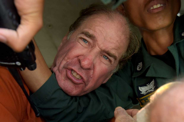 Sutradara asal Australia James Ricketson bereaksi ketika dia mencoba untuk berbicara dengan wartawan dari mobil tahanan usai menjalani sidang putusan di sebuah pengadilan di Phnom Penh, Jumat, 31 Agustus 2018. Pengadilan Kamboja memvonis James Ricketson bersalah melakukan tindak mata-mata dan menjatuhi hukuman enam tahun penjara. 