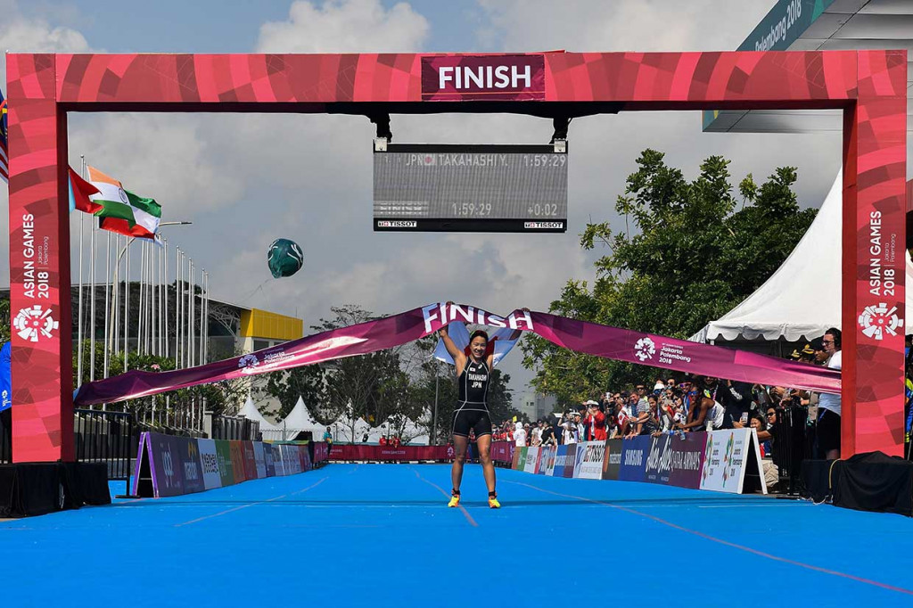 Atlet Jepang Yyki Takahashi menyentuh garis finis pertama pada perlombaan Triathlon Putri Asian Games 2018 di Jakabaring Sport City, Palembang, Sumatera Selatan, Jumat. AFP Photo/Mohd Rasfan