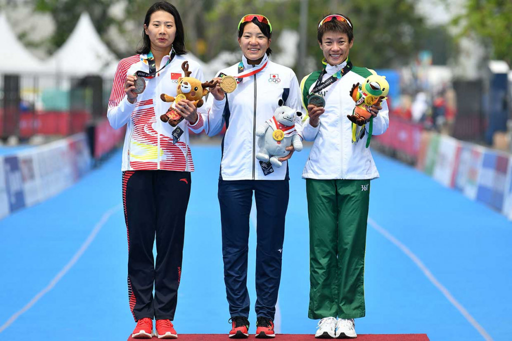 Yuko (tengah) finis pertama dengan catatan waktu 1 jam 59 menit dan 29 detik mengalahkan 21 kontestan lainnya. Medali perak diraih atlet Tiongkok Mengying Zhong (kiri) dengan selisih 1,47 detik lebih lama, dan perunggu didapatkan oleh Long Hoi dari Makau dengan selisih waktu 1,59 detik. AFP Photo/Mohd Rasfan