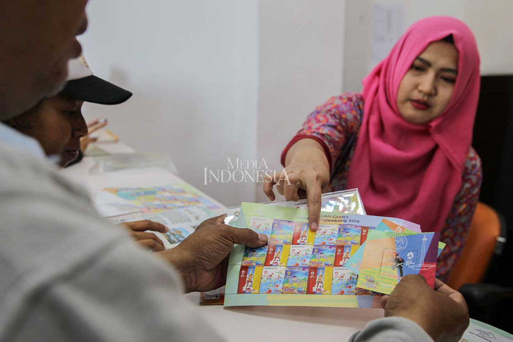 Petugas menunjukkan prangko edisi khusus Asian Games 2018 kepada calon pembeli di Kantor Filateli, Jakarta, Jumat, 31 Agustus 2018. 