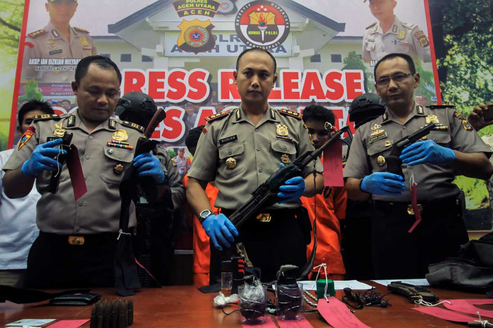 Kapolres Aceh Utara AKBP Ian Rizkian Milyardin (tengah) menunjukkan barang bukti yang berhasil disita dari para tersangka, di antaranya satu pucuk AK-56, satu pucuk pistol, dua granat nenas, 25 butir amunisi AK-56, satu magazen, dan tiga pisau sangkur.