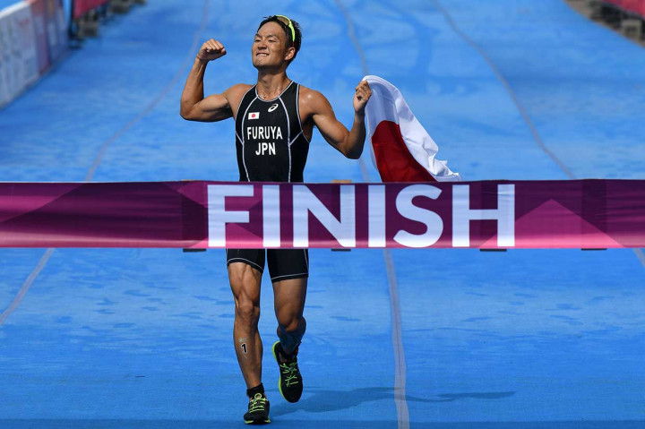 Atlet Jepang Jumpei Furuya melakukan selebrasi setelah berhasil menyentuh garis finis pertama pada nomor triathlon putra Asian Games 2018 di Palembang, Sabtu, 1 September 2018.