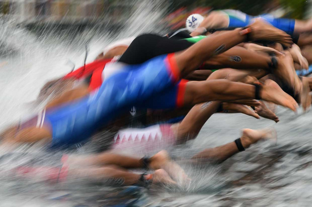 Para atlet melakukan start pada sesi renang sebelum lanjut ke tahap bersepeda dan lari di kawasan Jakabaring Sport City, Palembang. 