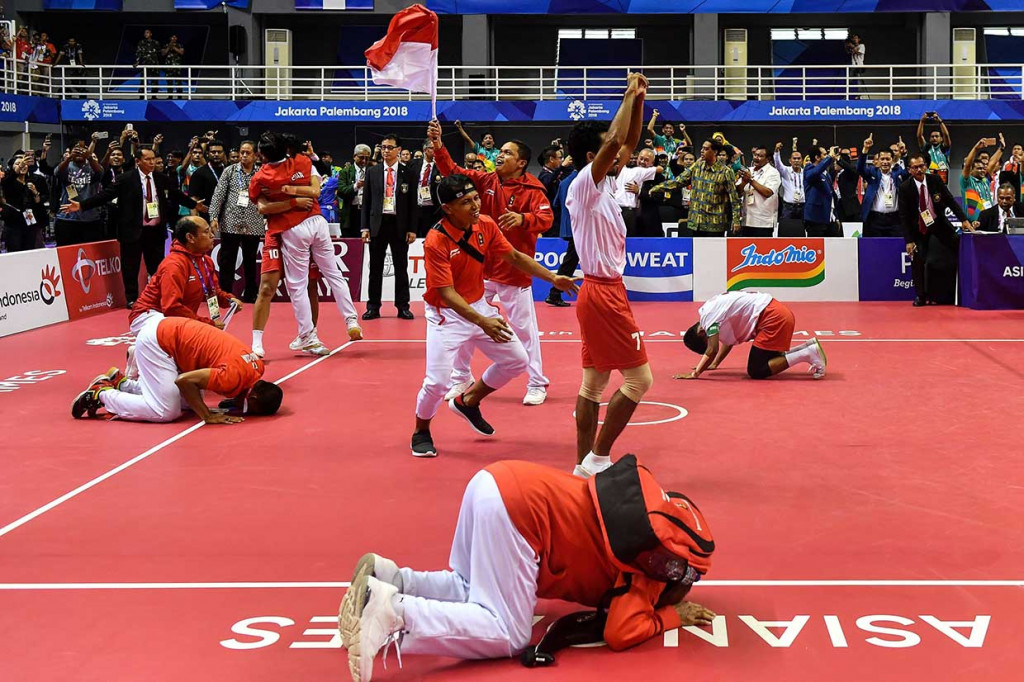 Pemain dan ofisial sepak takraw putra Indonesia meluapkan kegembiraan usai mengalahkan Jepang. AFP Photo/Mohd Rasfan