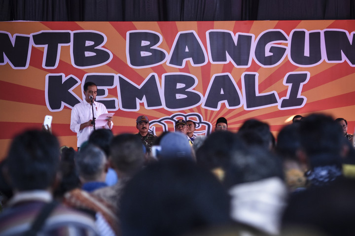 Presiden Joko Widodo (kiri) menyampaikan pidato sambutan usai memberikan bantuan korban gempa secara simbolis di Desa Pemenang Barat, Kecamatan Pemenang, Tanjung, Lombok Utara, NTB.