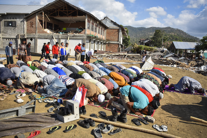 Sejumlah warga korban gempa menunaikan Salat Ashar saat menunggu Presiden Joko Widodo tiba untuk memberikan bantuan, di Desa Pemenang Barat, Kecamatan Pemenang, Tanjung, Lombok Utara, NTB.