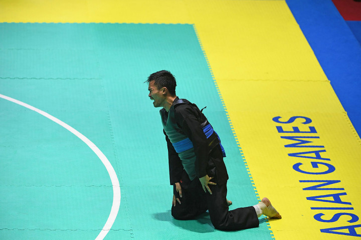 Pesilat Indonesia Abdul Malik menangis usai mengalahkan pesilat Malaysia Muhammad Faizul M Nasir dan meraih medali emas dalam babak final Kelas B Putra Asian Games 2018 di Padepokan Pencak Silat Taman Mini Indonesia Indah (TMII), Jakarta. Antara Foto/INASGOC/Melvinas Priananda