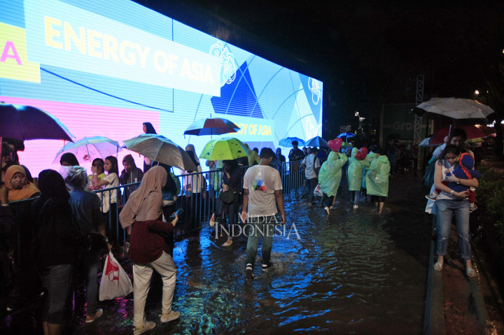 Hujan yang mengguyur ternyata tak jadi halangan bagi para penonton untuk memeriahkan penutupan perhelatan multicabang terbesar di Asia tersebut. Mereka sudah mempersiapkan diri dengan payung dan jas hujan. MI/Rommy Pujianto
