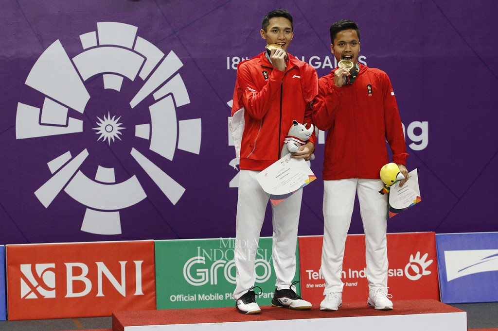 Pebulu tangkis nasional Jonatan Christie dan Anthony Ginting menunjukkan medali emas dan perunggu yang diraihnya seusai mengalahkan pebulu tangkis Taiwan Tienchen Chou pada final bulu tangkis tunggal putra Asian Games 2018 di Istora Senayan, Komplek GBK, Jakarta, Selasa (28/8). Jojo menambah raihan medali emas Indonesia setelah kalahkan lawannya dengan skor 2-1 (21-18, 20-22 dan 21-15). MI/Rommy Pujianto