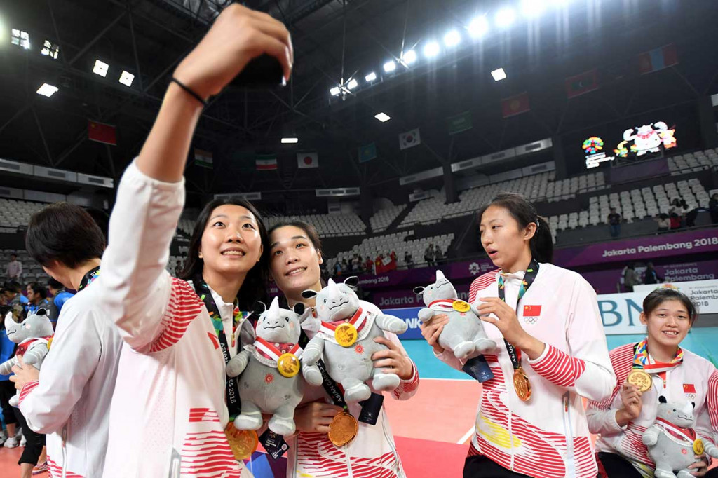 Pemain dan offisial tim voli putri Tiongkok berswafoto setelah menerima penghargaan medali emas. Tim bola voli putri Tiongkok mengandaskan harapan Thailand untuk merebut medali emas dengan kemenangan tiga set langsung, 25-19, 25-17,25-13. INASGOC/Antara Foto/Syaiful Arif