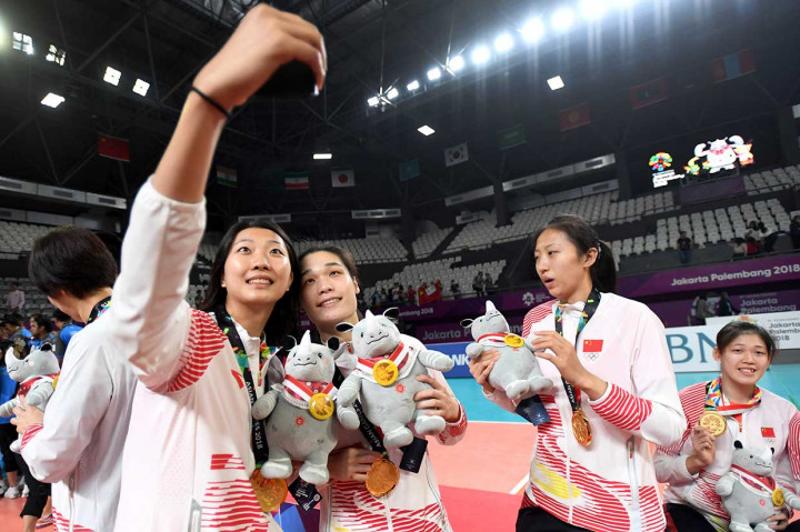 Pemain dan offisial tim voli putri Tiongkok berswafoto setelah menerima penghargaan medali emas. Tim bola voli putri Tiongkok mengandaskan harapan Thailand untuk merebut medali emas dengan kemenangan tiga set langsung, 25-19, 25-17,25-13. INASGOC/Antara Foto/Syaiful Arif