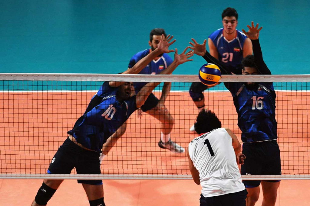Pebola voli Iran Ali Shafiei (16) danm Amir ghafour (10) memblok smash yang dilancarkan pebola voli Korea Selatan Song Myunggeun pada final bola voli putra Asian Games. AFP Photo/Sony Tumbelaka