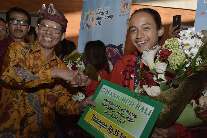 Penjabat Gubernur Bali Hamdani (kedua kiri) berfoto dengan peraih medali perak cabang olahraga skateboard Asian Games 2018, Sanggoe Dharma Tanjung (kanan), saat tiba di Bandara I Gusti Ngurah Rai, Badung, Bali, Senin (3/9). 