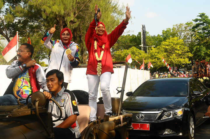 Atlet panjat tebing Indonesia peraih medali emas Asian Games 2018 Aries Susanti Rahayu (kanan) dan Bupati Grobogan Sri Sumarni (kedua kanan) menyapa warga saat penyambutan dan arak-arakan di Grobogan, Jawa Tengah, Selasa (4/9). Penyambutan tersebut dilakukan untuk merayakan prestasi yang diraih oleh Aries Susanti Rahayu atas raihan dua medali emas cabang olahraga panjat tebing dari nomor speed putri dan speed relay putri. Antara Foto/Yusuf Nugroho
