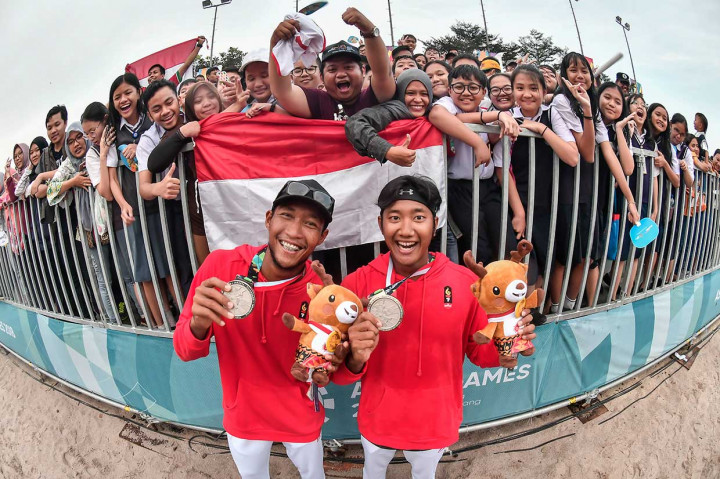 Pevoli pantai putra Indonesia Mohammad Ashfiya (kanan) dan Ade Candra Rachmawan berfoto bersama pendukung Indonesia usai menerima medali perak. INASGOC/Antara Foto/Muhammad Adimaja