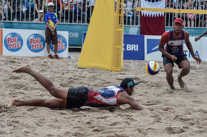 Pevoli pantai putra Indonesia Mohammad Ashfiya (kiri) dan Ade Candra Rachmawan mencoba mengembalikan bola ke arah pevoli Qatar. INASGOC/Antara Foto/Muhammad Adimaja