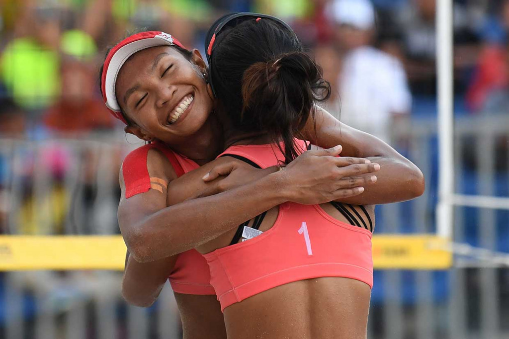 Pevoli pantai putri Indonesia Putu Dini Jasita Utami (kanan) dan Dhita Juliana (kiri) melakukan selebrasi usai mengalahkan duet Kazakhstan. AFP Photo/Mohd Rasfan