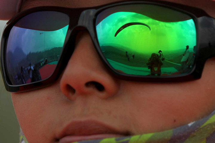 Penerbang paralayang putri Tiongkok Li Chennan mengamati rekan setimnya saat tinggal landas dalam babak kelima ketepatan mendarat Asian Games 2018 di Gunung Mas Puncak, Bogor, 21 Agustus. Antara Foto/INASGOC/Crack Palinggi