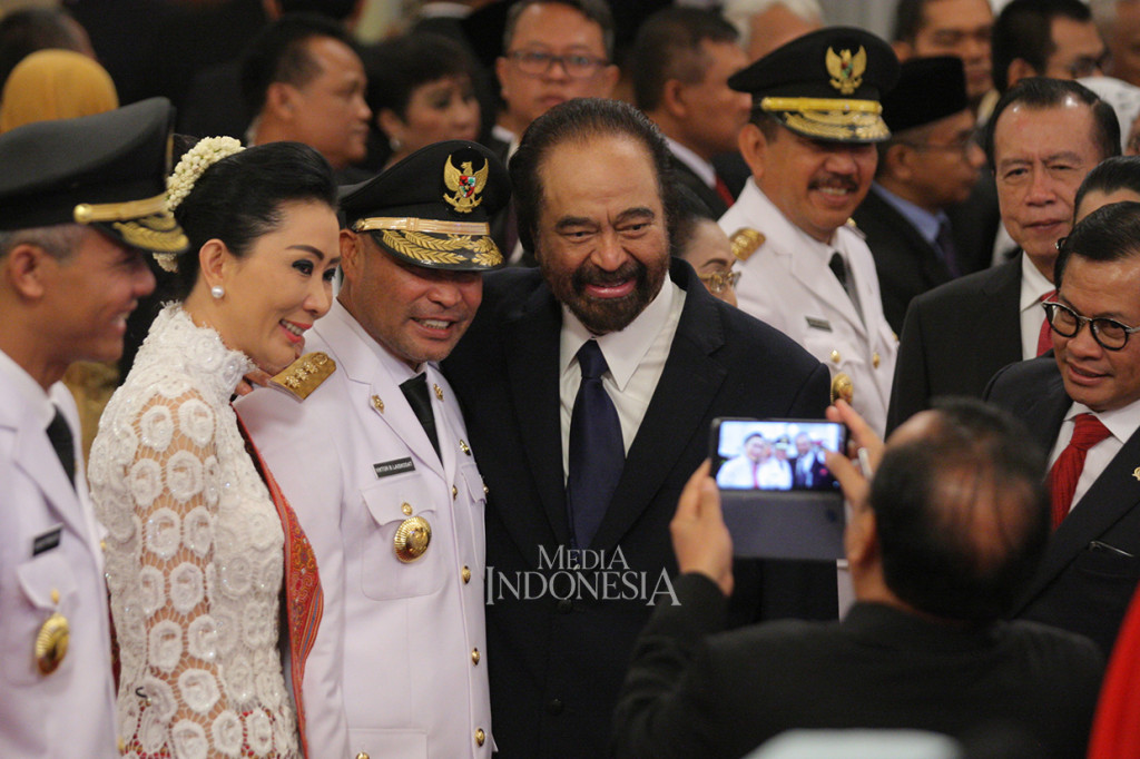 Ketua Umum Partai NasDem Surya Paloh (tengah) foto bersama dengan Gubernur terpilih Nusa Tenggara Timur yang juga merupakan kader dari Partai NasDem, Viktor Laiskodat dan istri, disaksikan Gubernur Jawa Tengah Ganjar Pranowo (kiri) seusai pelantikan di Istana Negara , Jakarta.