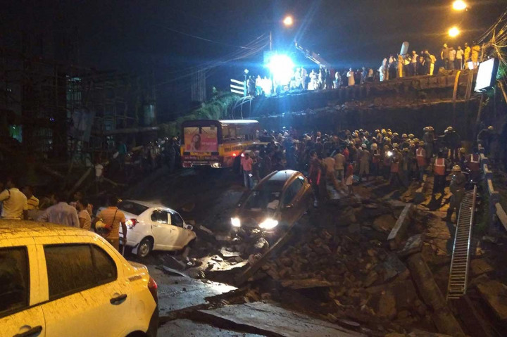 Petugas penyelamat dan personel pertahanan sipil India berusaha mencari korban di antara reruntuhan jembatan yang tiba-tiba roboh di Kolkata, Benggala Barat, Selasa, 4 September 2018.