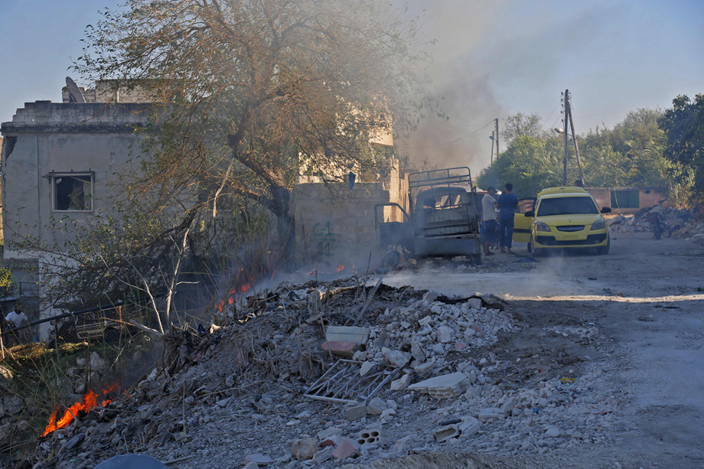 Warga Suriah yang dievakuasi dalam sebuah taksi dari tempat serangan udara yang dilaporkan di distrik Jisr al-Shughur, di provinsi Idlib. Afp Photo/Zein Al Rifai